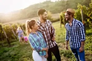 Happy people tasting wine in vineyard